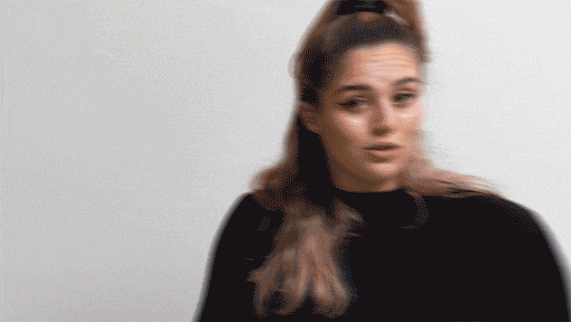 Gif of woman in turtleneck reacting with surprise and confusion in conversation.